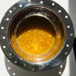 hot honey vinaigrette in a silver bowl.