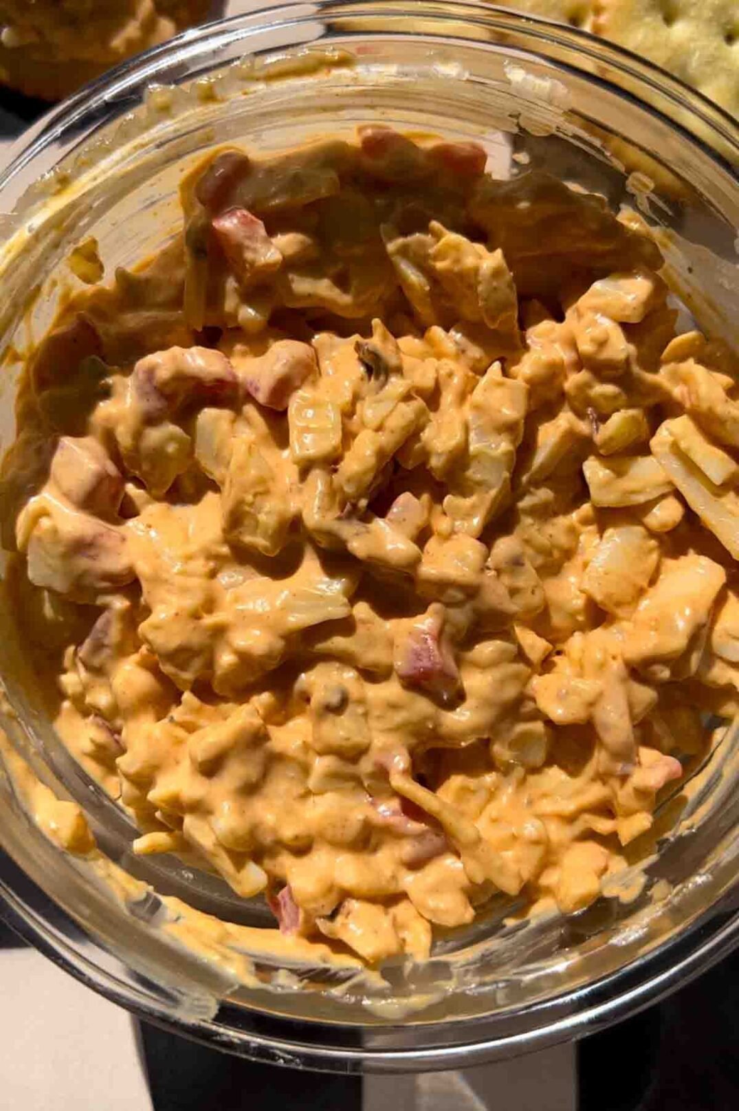 a close up of a bowl of spicy pimento cheese dip.