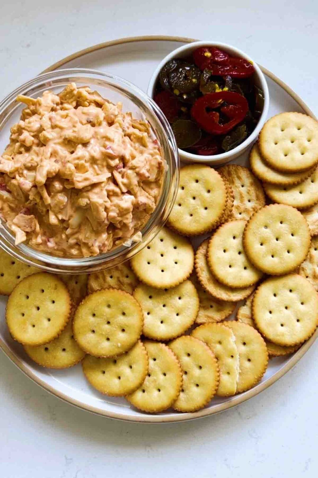 a cracker plate with spicy pimento cheese dip in a glass bowl. 