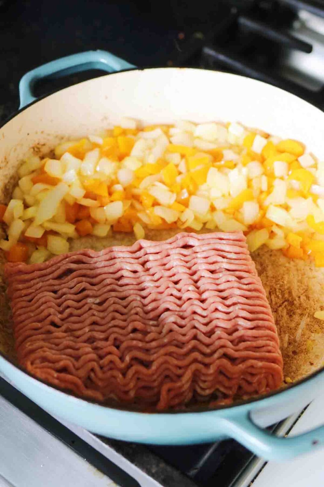 turkey pastelon ingredients in blue fry pan. 