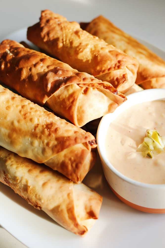 a stack of Disney's Cheeseburger Spring Rolls on a plate. 