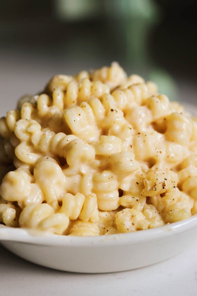 a white bowl filled with creamy macaroni and cheese using gouda cheese. 