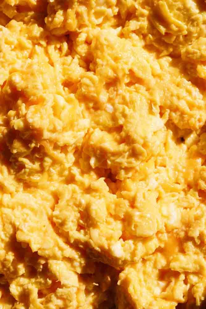 a close up of a place of perfectly scrambled cheesy eggs. 
