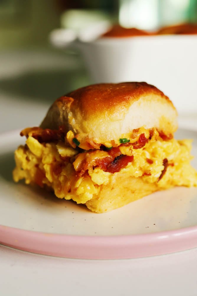 a single breakfast slider sitting on a white plate on a white countertop. 