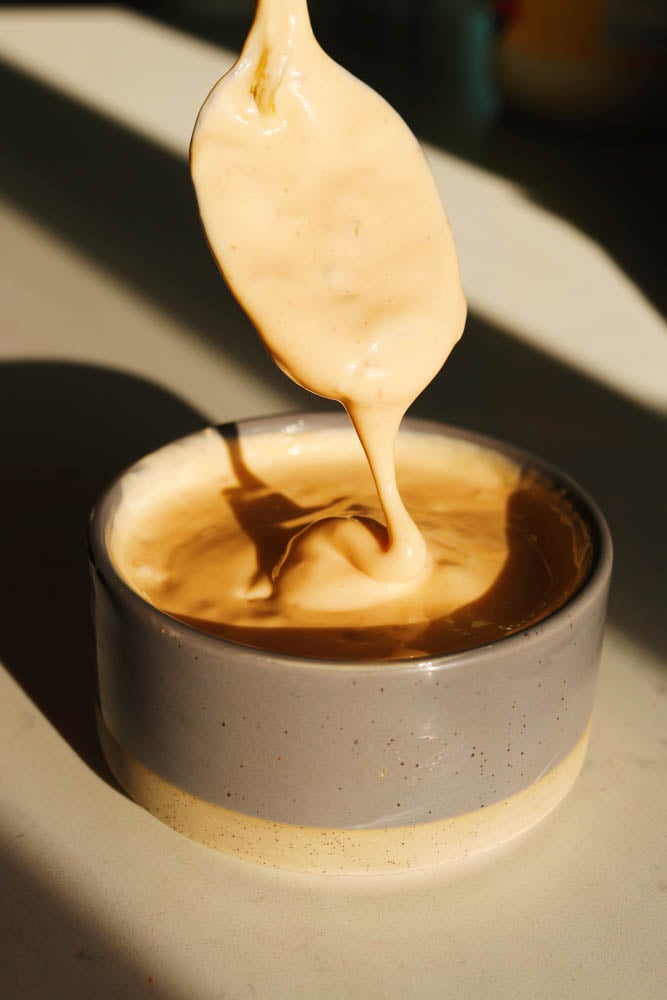 a drizzle of smashburger sauce coming off of a spoon. 