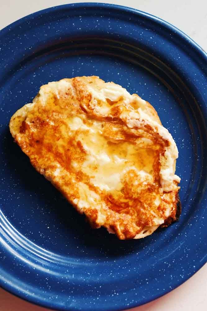 a blue plate topped with a piece of crispy feta toast. 