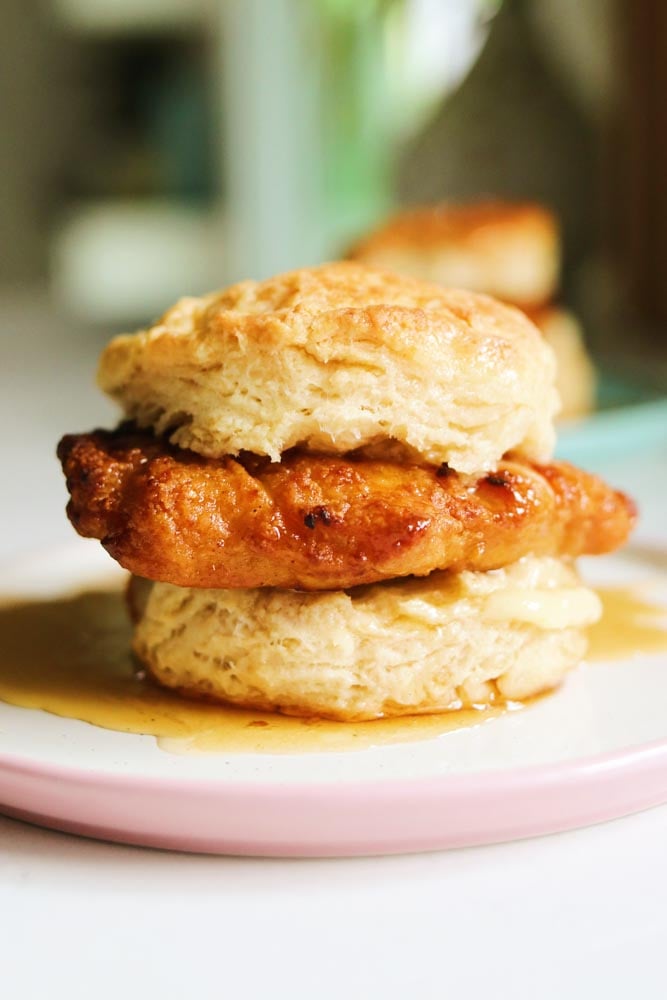a single honey butter chicken biscuit sitting on a table. 