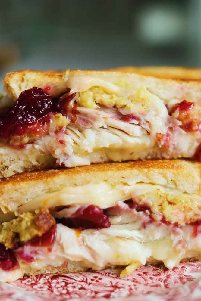 a close up of the inside of a turkey cranberry sandwich. 