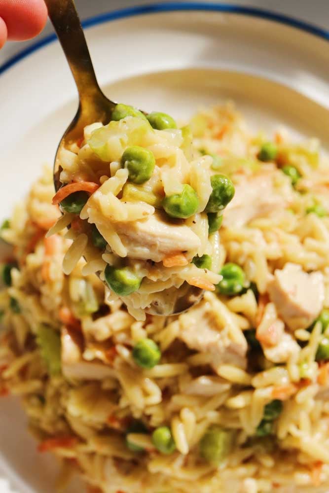 a spoon holding a scoop of chicken pot pie orzo. 
