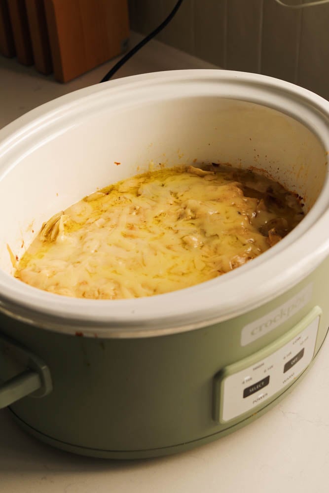 A crockpot full of cheesy gruyere potatoes au gratin. . 