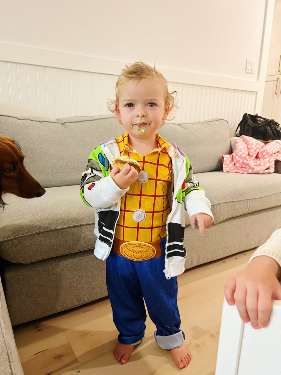 a kid in a buzz light year sweater and woody costume. 