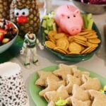 toy story themed food for a birthday party on a white table with toys around it.