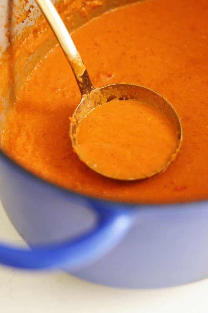 creamy tomato soup in a large blue dutch oven. '