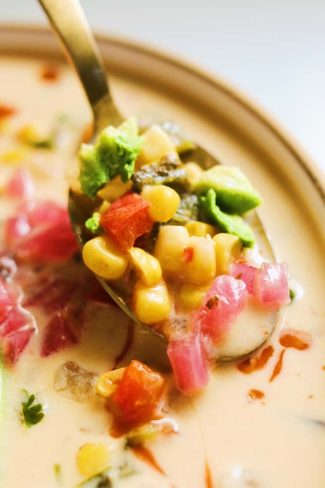 a golden spoon full of mexican street corn soup.