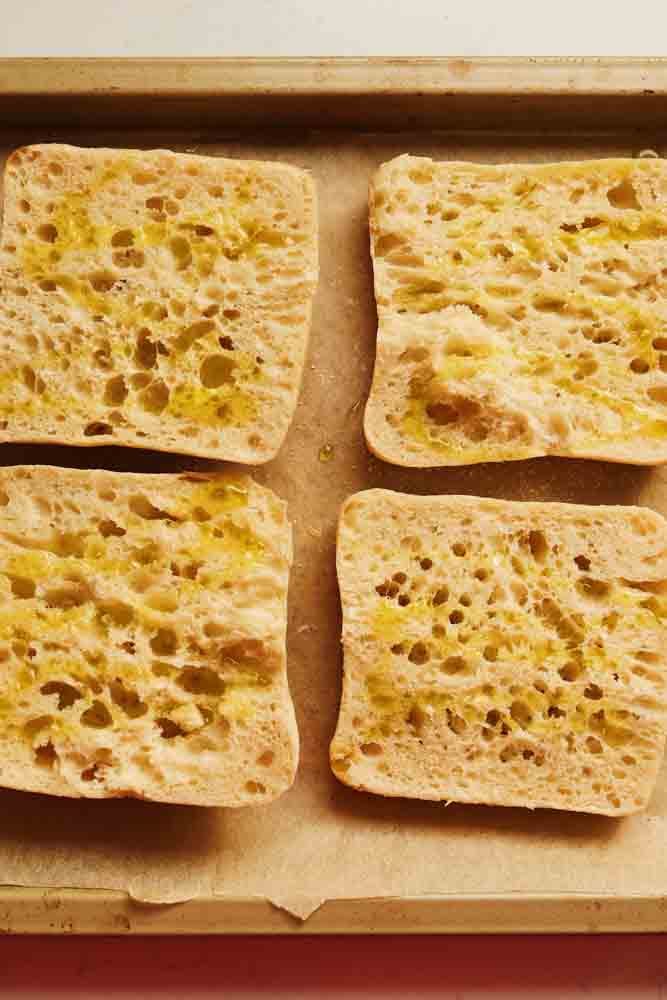 garlic rubbed ciabatta bread on a baking sheet. 