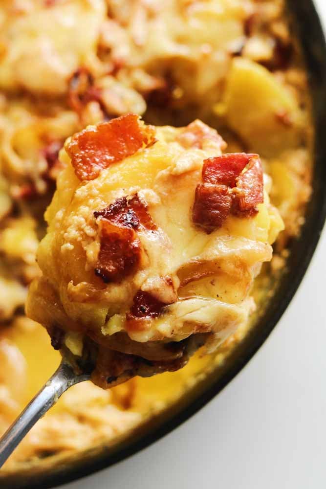 a scoop of tartiflette with cheese and bacon all over it.