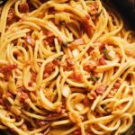 an overhead view of a black cast iron skillet filled with kimchi carbonara