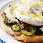 a close up of caramelized zucchini topped with burrata.