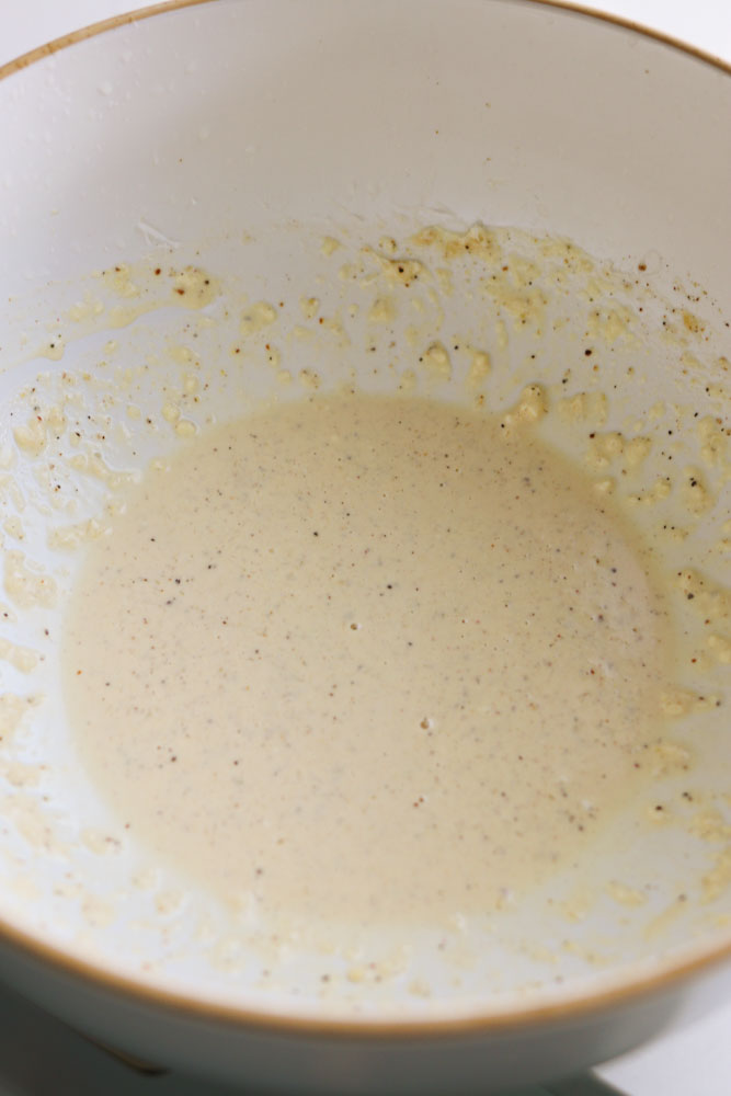 caesar dressing without anchovies in a white bowl.