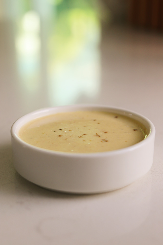 a tiny white ceramic bowl filled with caesar dressing that's made without anchovies.