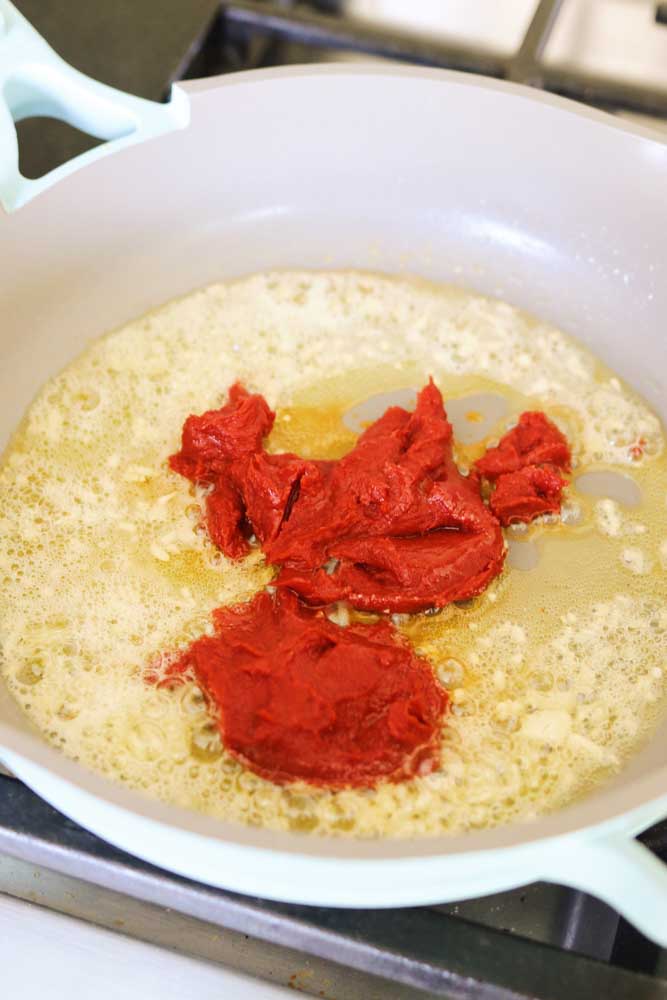 tomato paste in a pan with melted butter and garlic. 