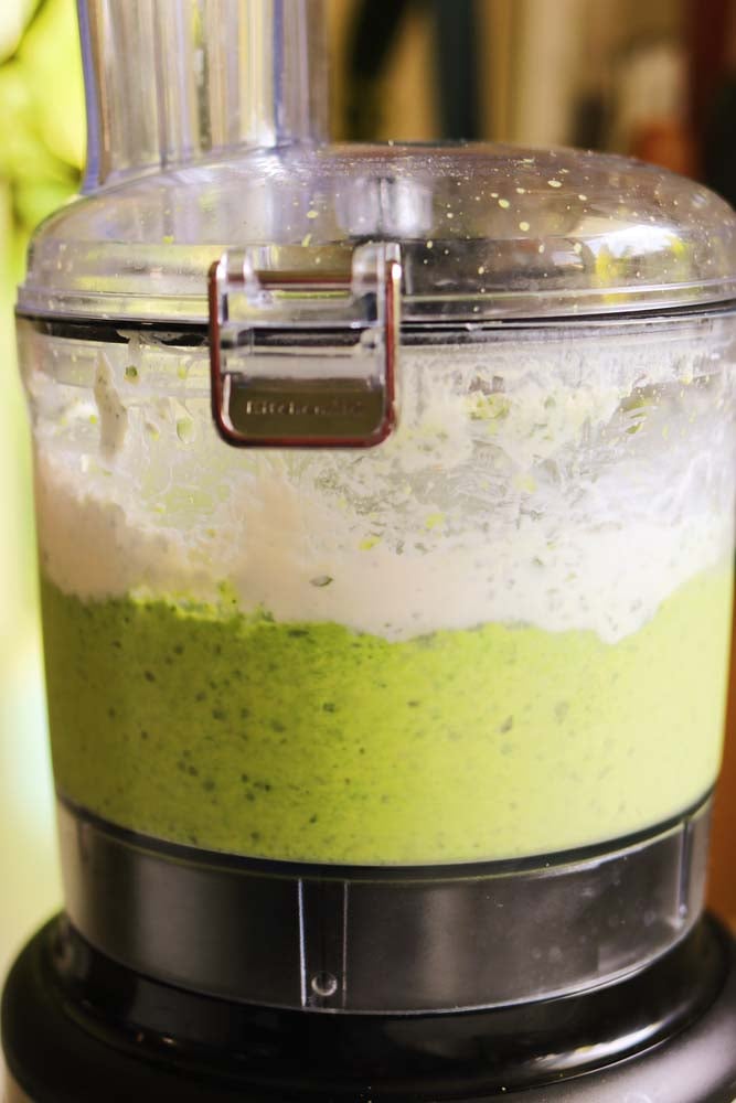 the inside of a food processor with a smooth and creamy green pasta sauce