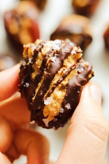 a hand holding a peanut butter stuffed date.