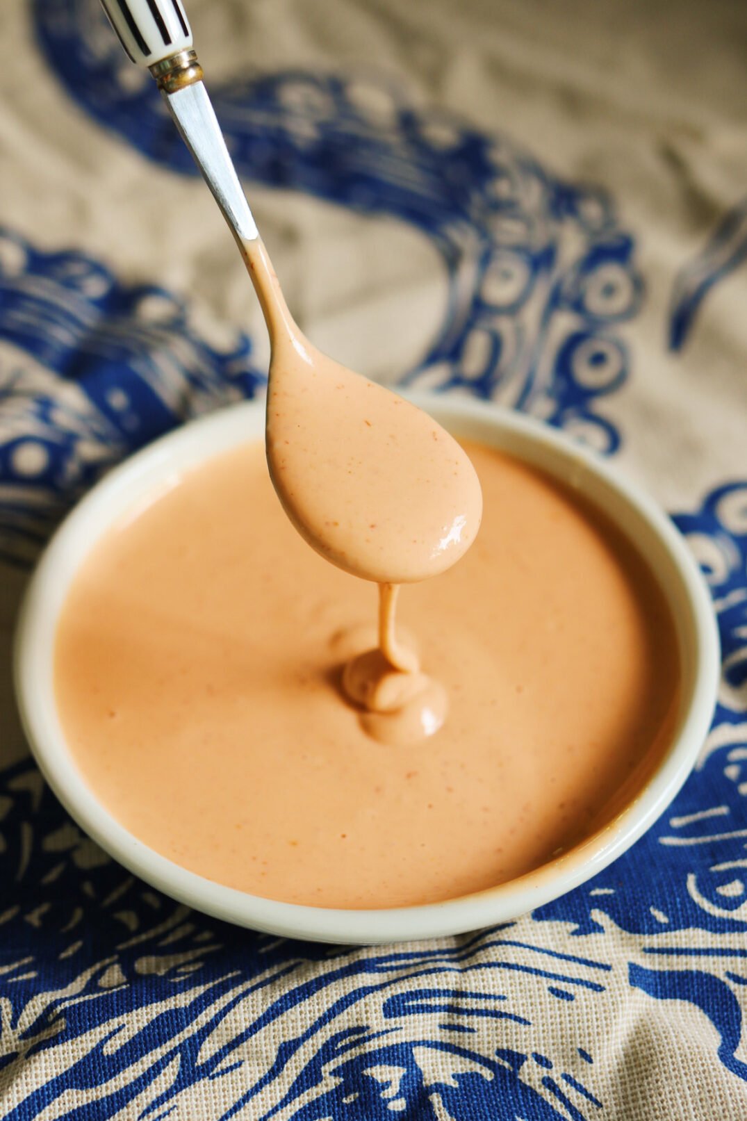 easy spicy mayo sauce in a small bowl with a silver spoon. 