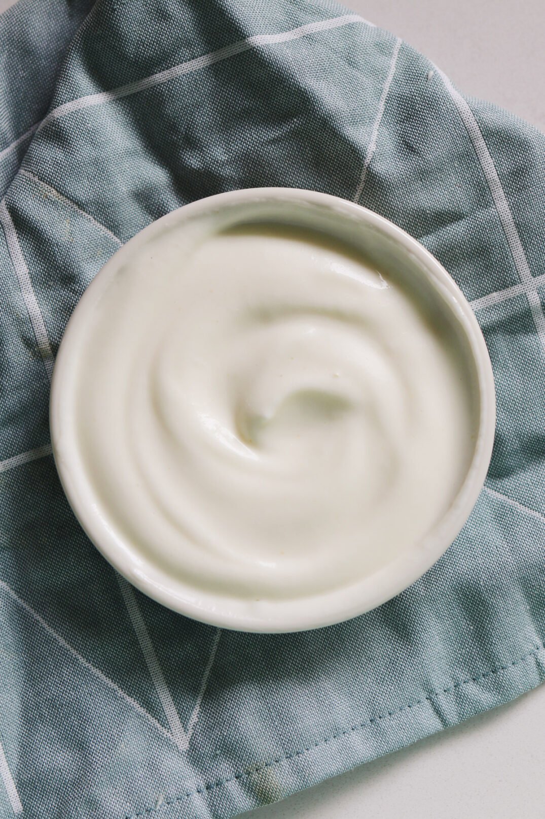 a small white bowl of white garlic sauce for shawarma