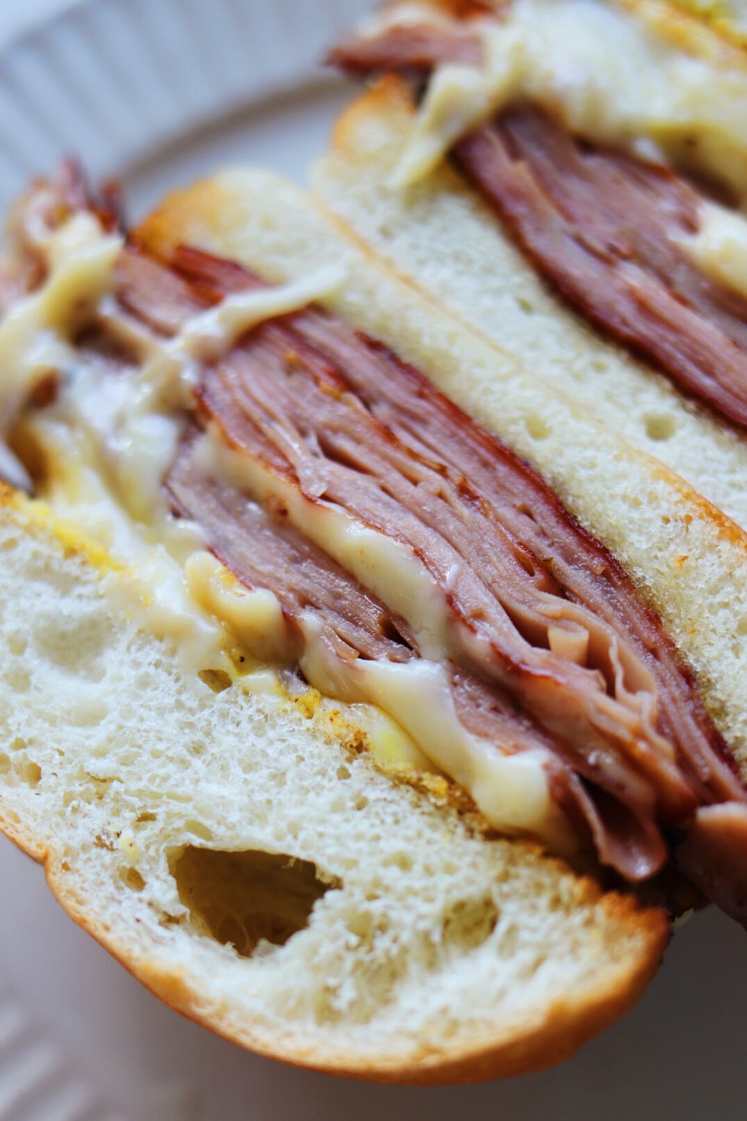 an up close view of the fried mortadella layers in bourdains mortadella sandwich.