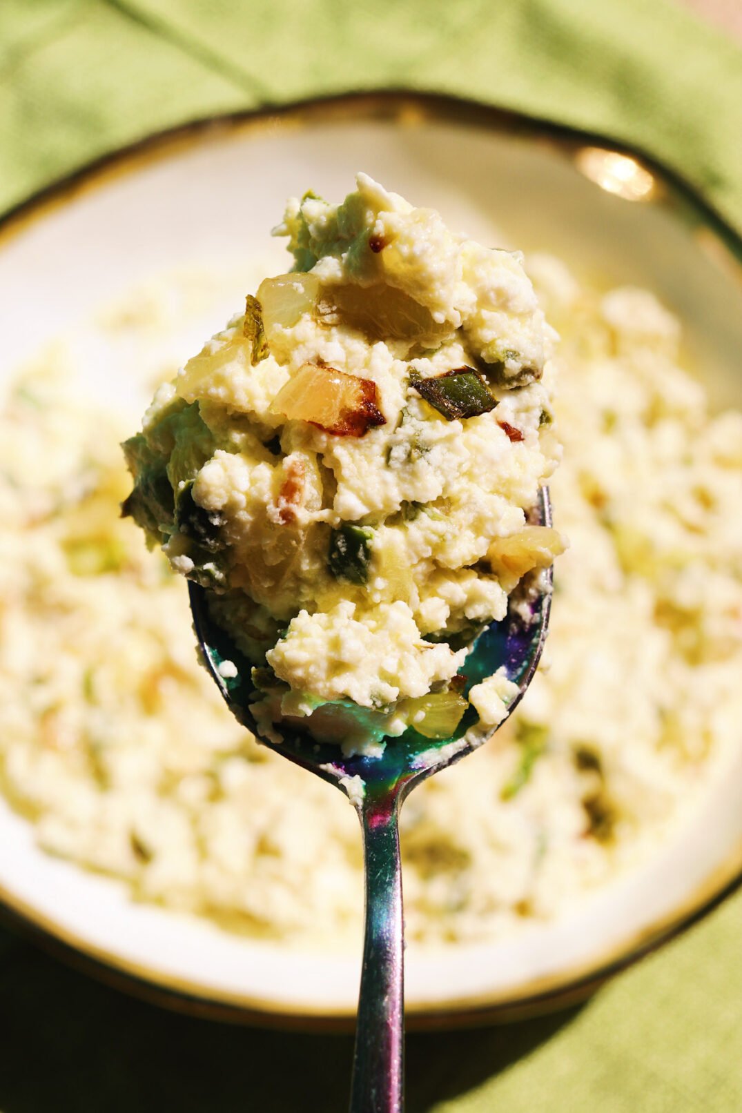 a spoon of cava's crazy feta spicy jalapeno dip over a bowl of the dip. 
