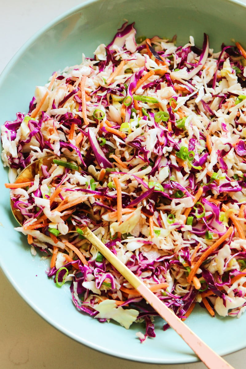 a big blue bowl of colorful tangy coleslaw for pulled pork.