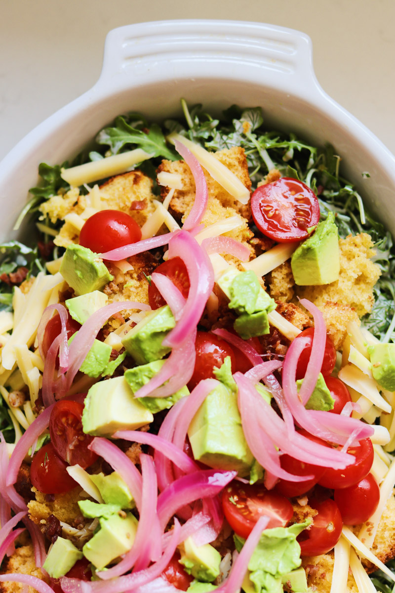 overhead view of a colorful cornbread salad recipe in a large bowl.