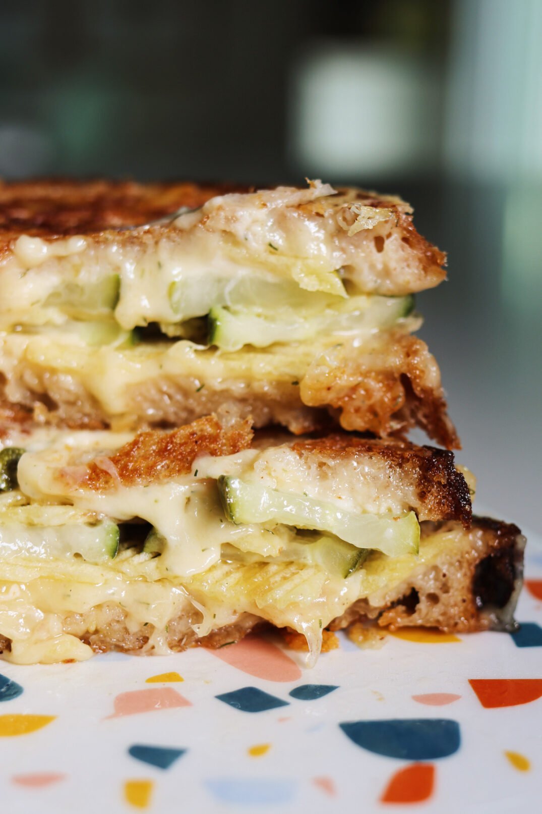 a close up of two halves of a dill pickle grilled cheese.