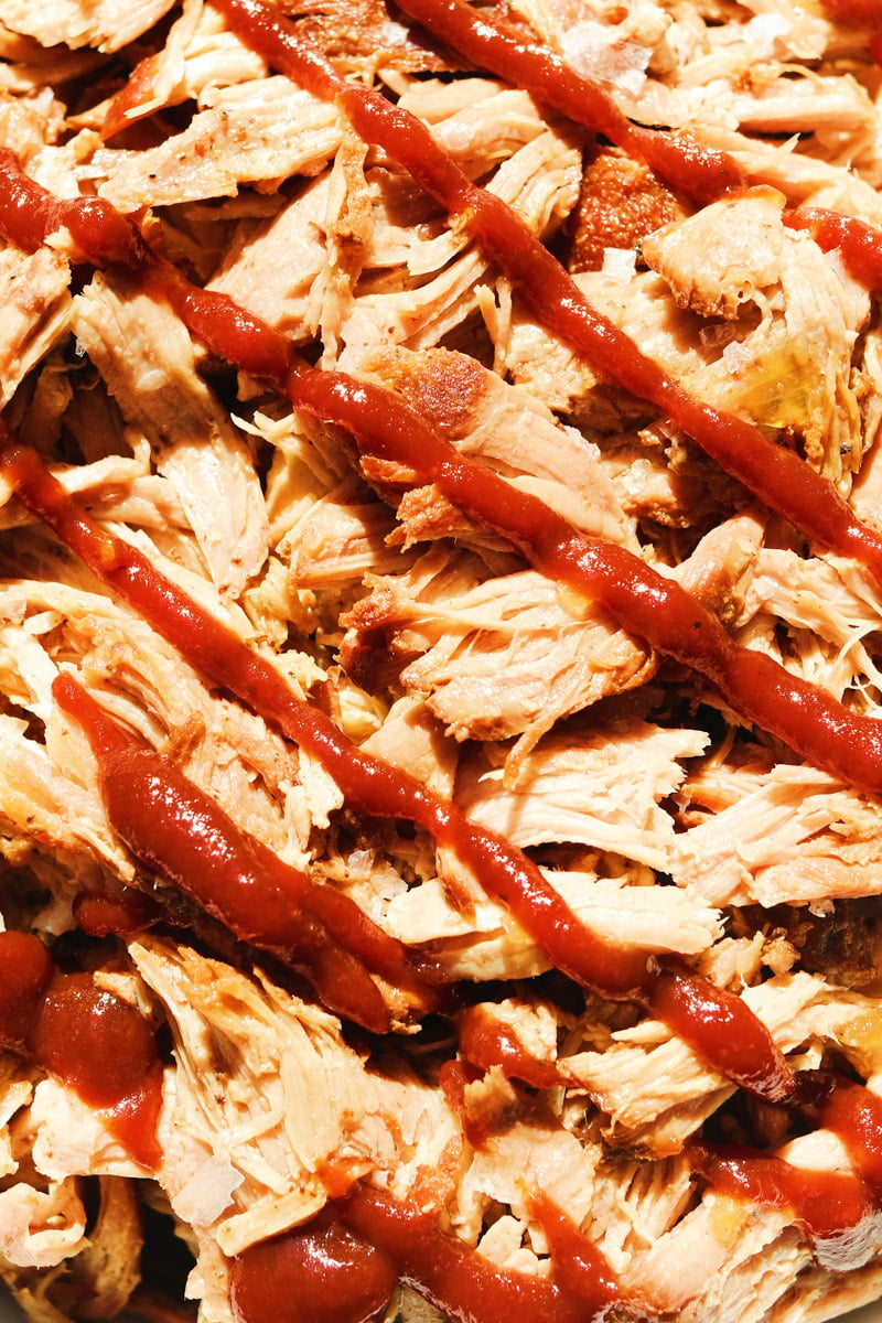 an up close view of some pulled pork drizzled with bbq sauce.
