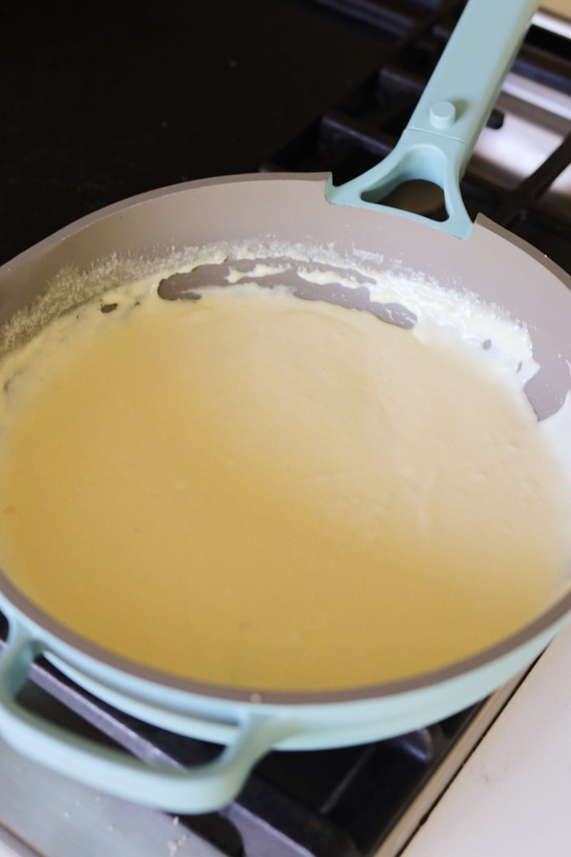 creamy alfredo sauce with cream cheese in a blue pot. 