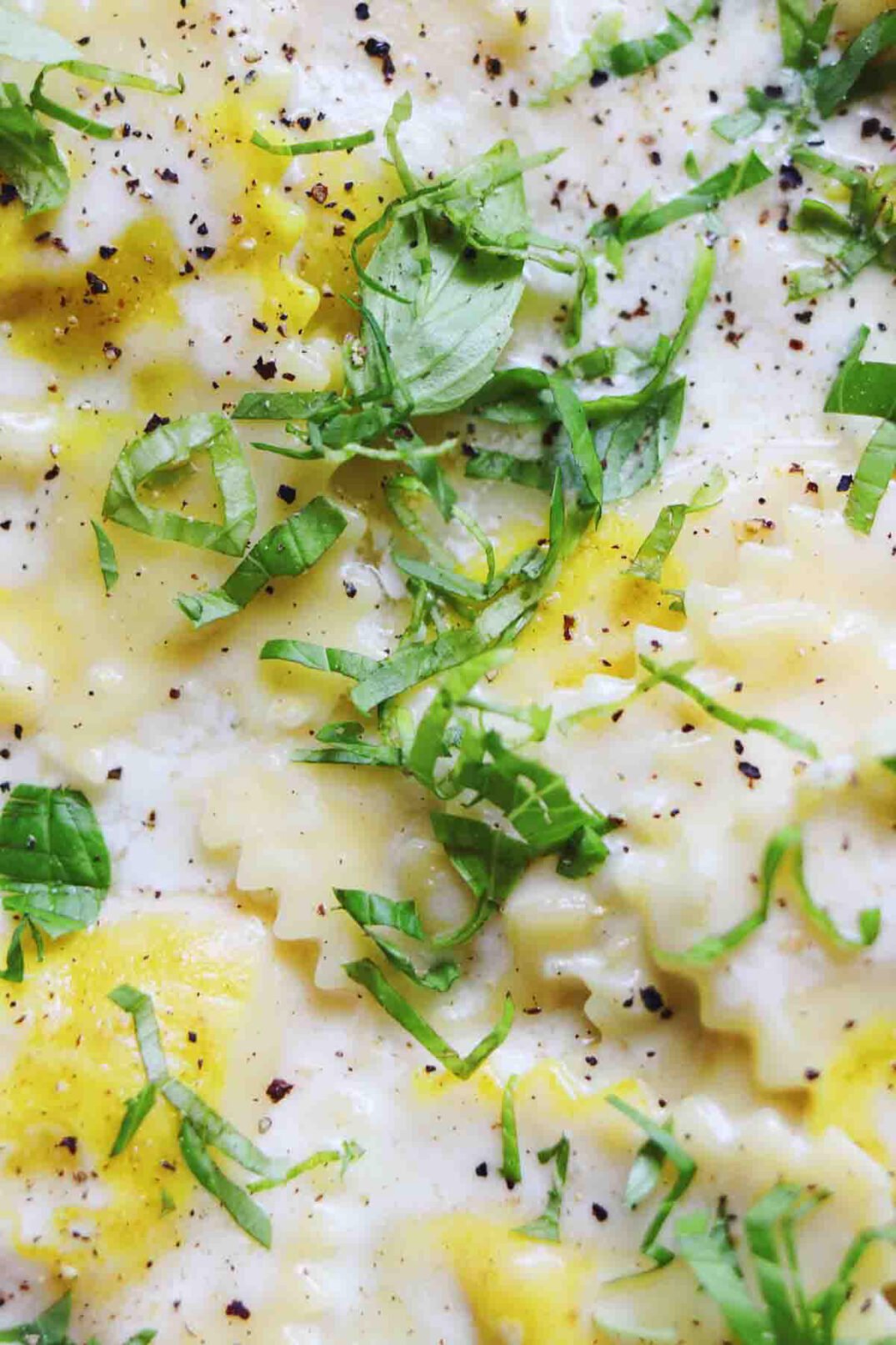 an up close view of trader joes sweet corn ravioli with fresh basil on top. 
