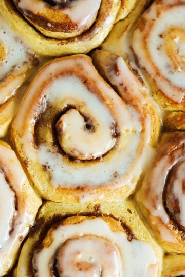 tiktok cinnamon rolls with heavy cream in a baking dish.