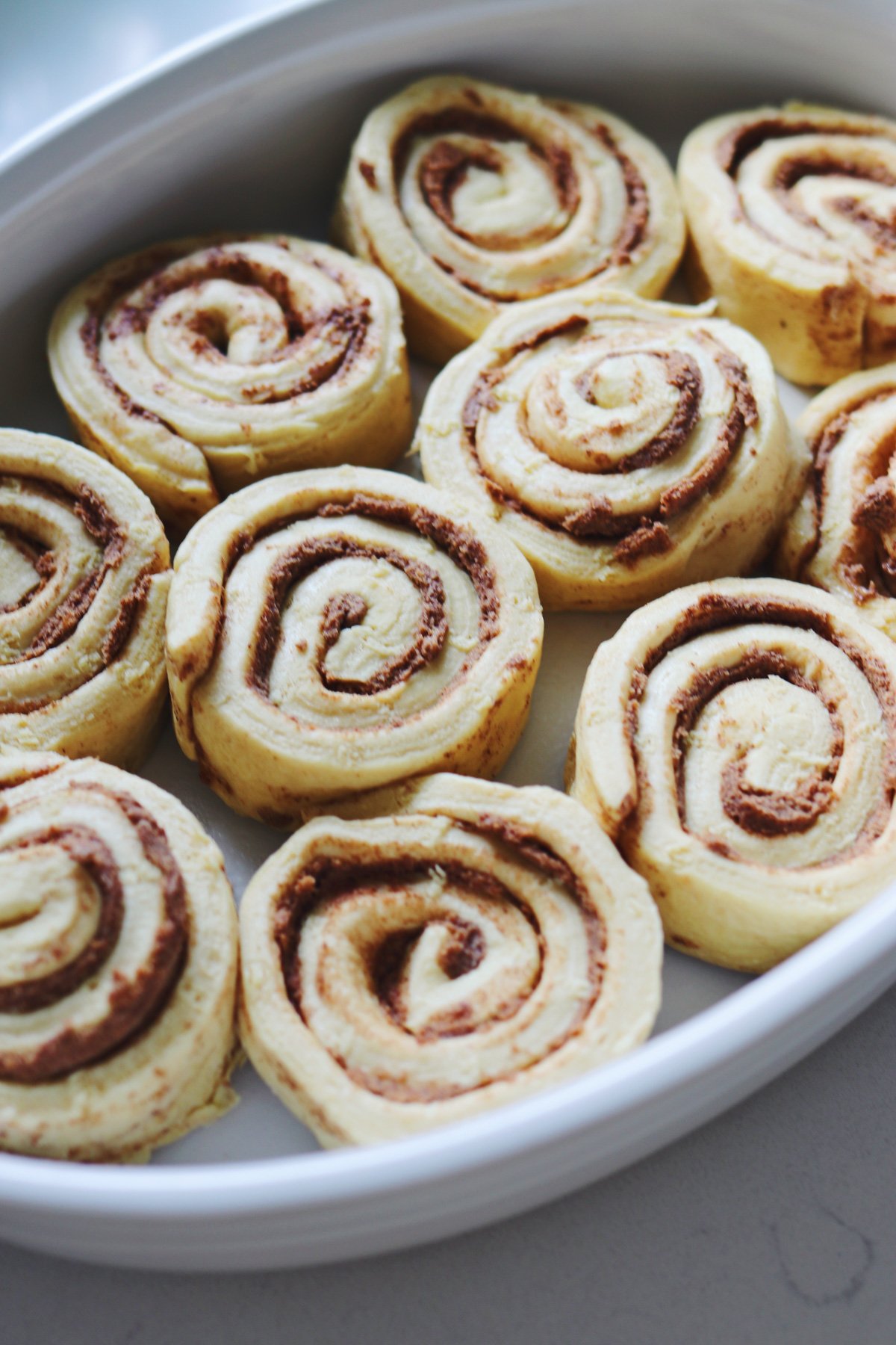 raw grands cinnamon buns in a baking dish about to get baked. 