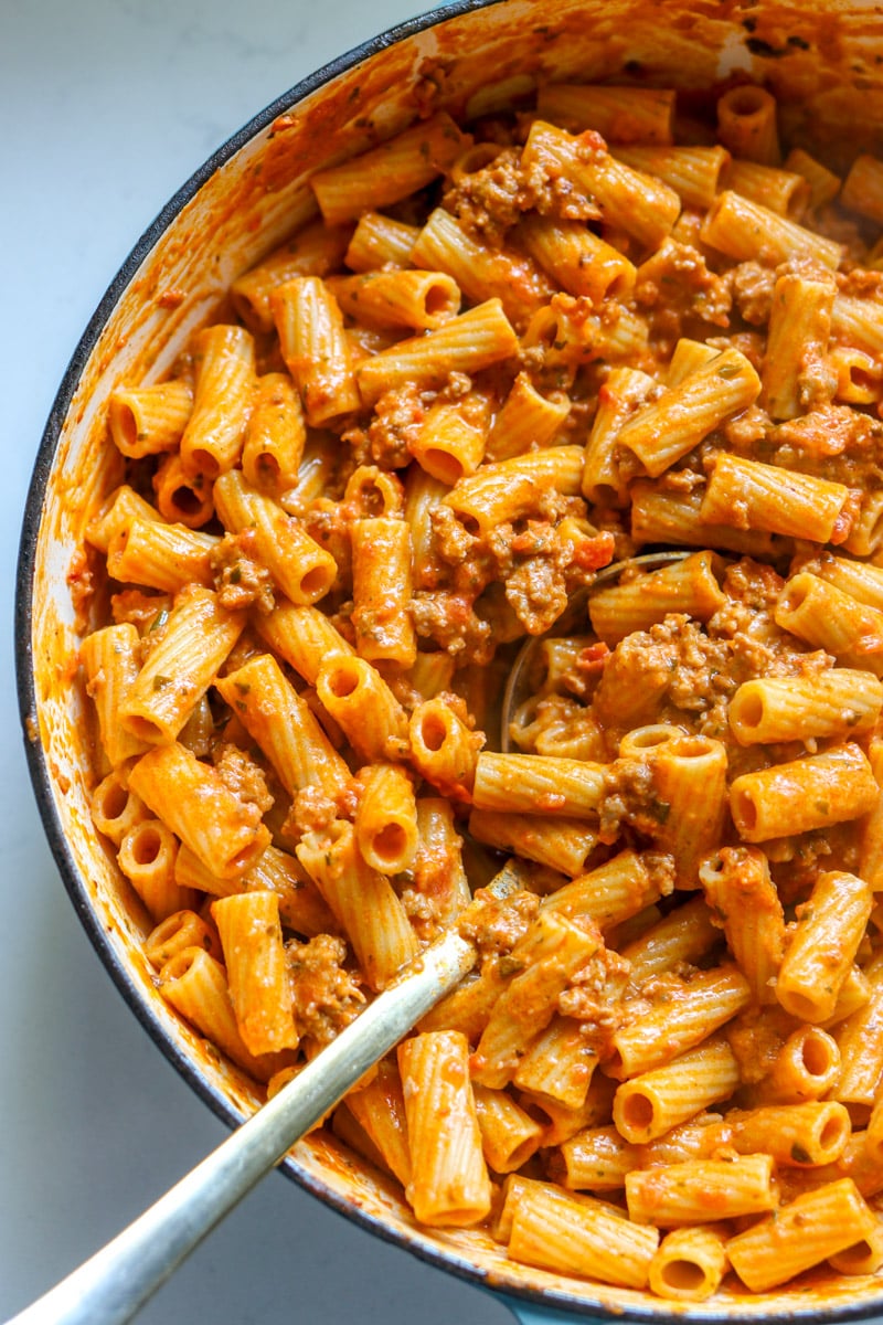 a pot filled with boursin and sausage pasta.