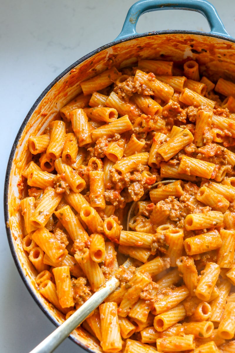 a big braiser full of 4 ingredient pasta with sausage and boursin cheese tomato sauce. 