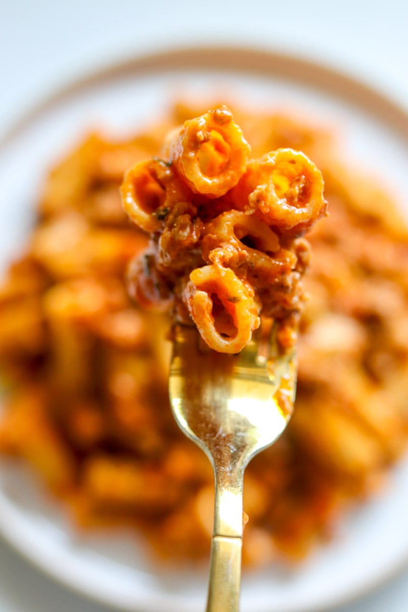 a fork holding a bite of boursin and sausage pasta.