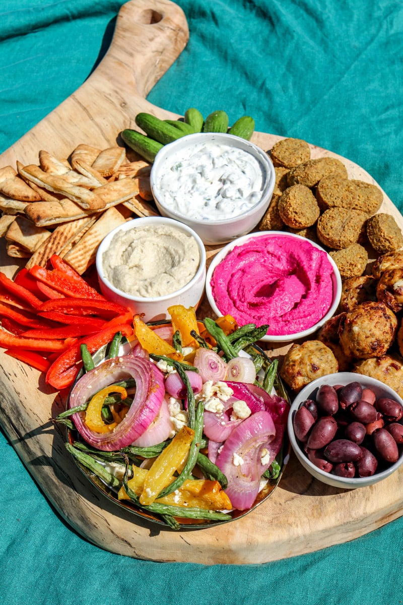  a Greek Appetizer Platter with colorful spreads and contrasting textures on a blue table. 