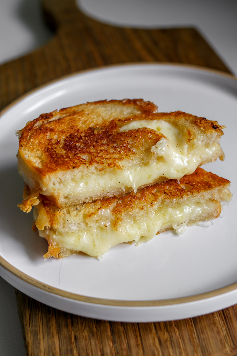 two halves of a garlic bread grilled cheese stacked on top of each other.