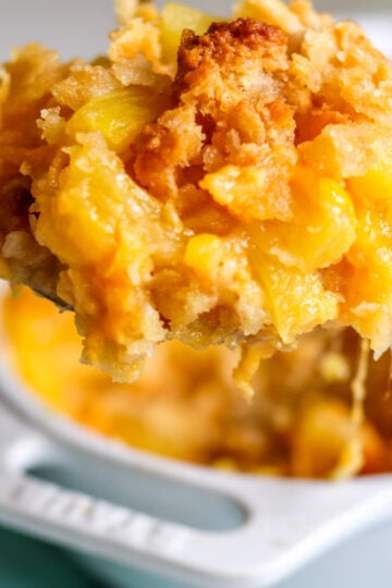 a spoon full of pineapple cheese casserole.