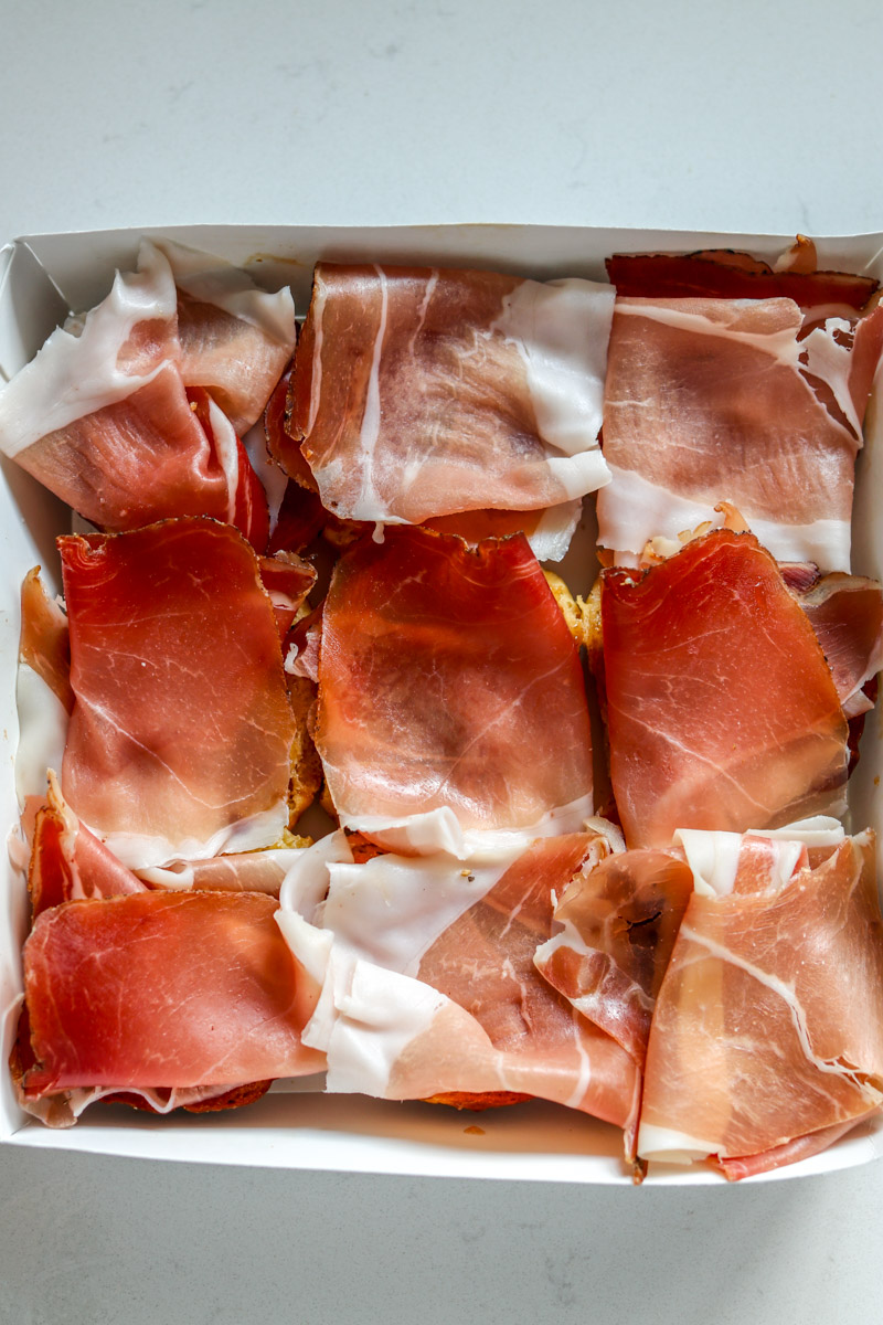 prosciutto slices on top of pieces of bread.