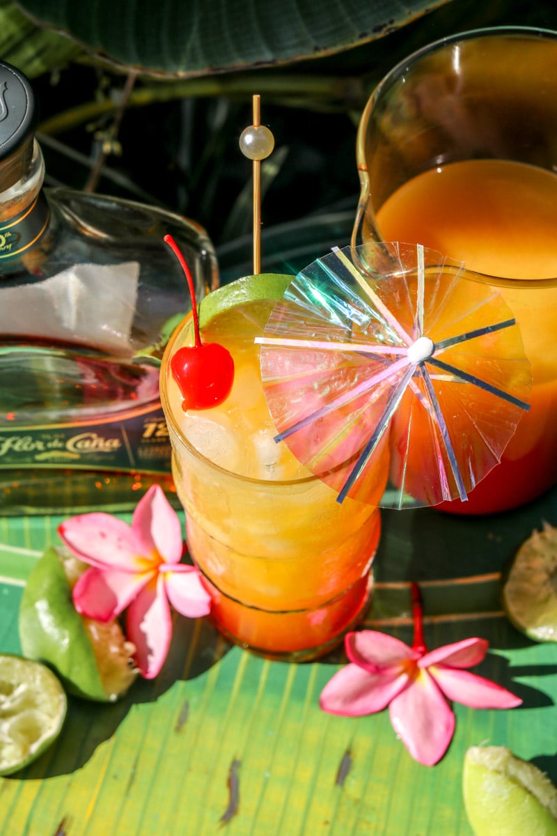 an overhead view of a rum punch cocktail in a tall glass with a cocktail umbrella. 