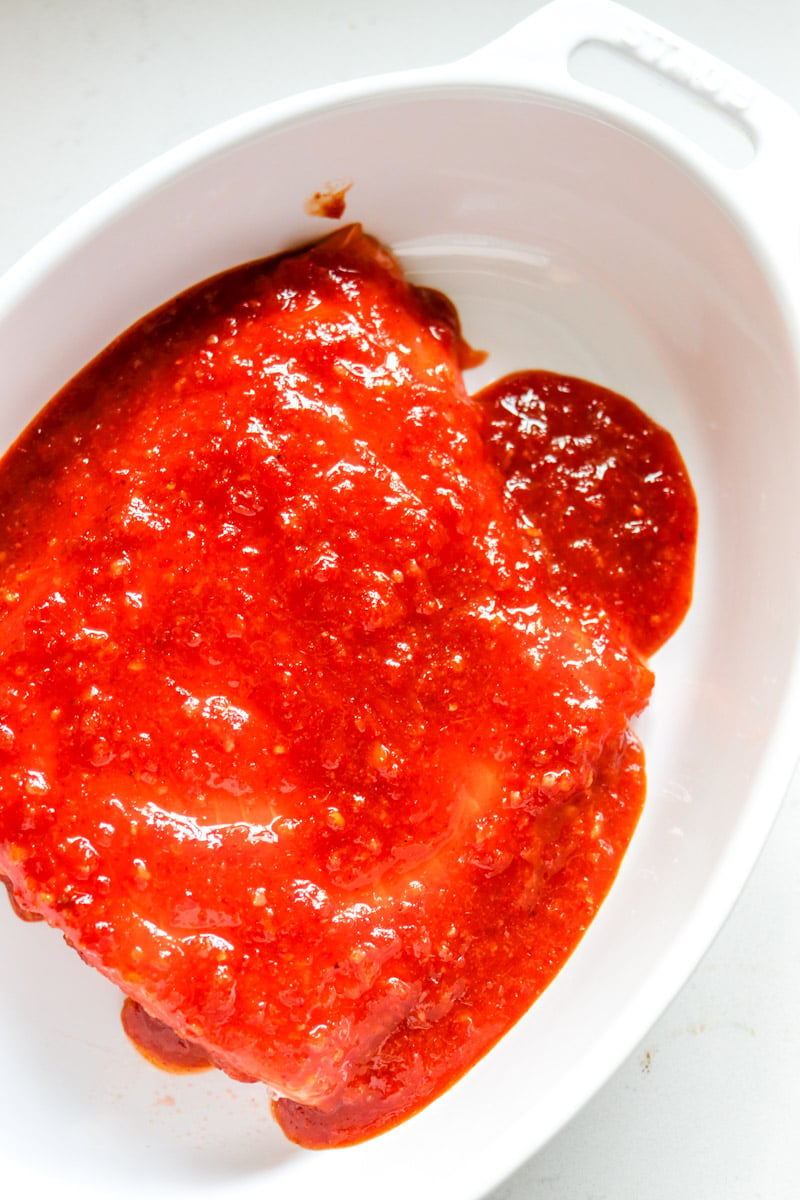 raw salmon covered in a bright red spicy sauce. 