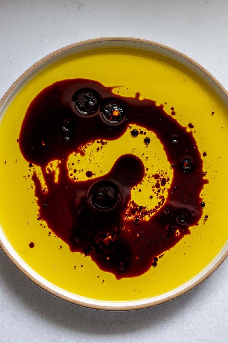 olive oil and balsamic swirled on a white plate. 