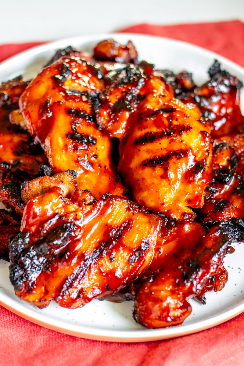 a birds eye view of some bbq chicken on a white plate. 